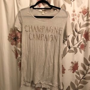 White top with Champagne campaign in gold script